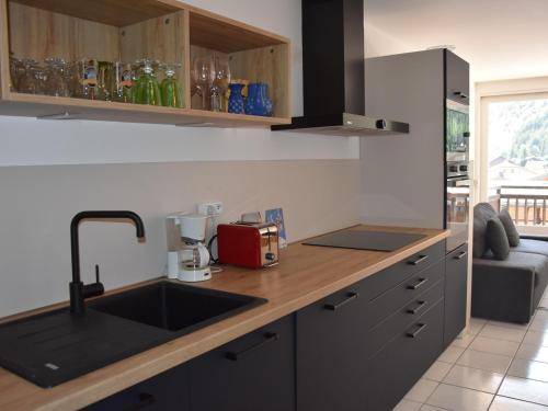 une cuisine avec un évier et un comptoir dans l'établissement Beau T3 rénové, terrasse sud, près commerces & téléphérique - FR-1-464-238, à Pralognan-la-Vanoise