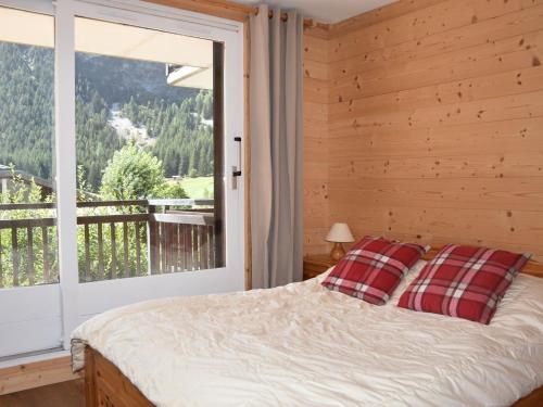 une chambre avec un lit et une grande fenêtre dans l'établissement Beau T3 rénové, terrasse sud, près commerces & téléphérique - FR-1-464-238, à Pralognan-la-Vanoise