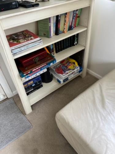 a book shelf filled with books next to a bed at Janie s Cottage Secluded Wine Country Home in Broke