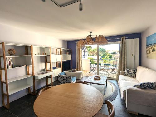 un salon avec une table et un canapé dans l'établissement T3 neuf à Arcachon : terrasse, parking et wifi - FR-1-420-153, à Arcachon