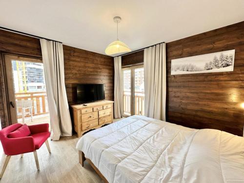 une chambre avec un lit blanc et une chaise rouge dans l'établissement Résidence Le Living Stone B - NOUVEAU CENTRE, PIED DES PISTES-Tout inclus MAE-0941, à Vars