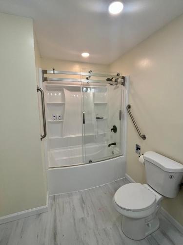 a white bathroom with a toilet and a shower at Notre Dame vs USC, 5 BR Ranch Walk to Campus, 2 Full Baths, Game Room in South Bend