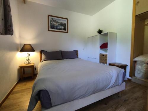 une chambre avec un grand lit blanc et une lampe dans l'établissement Résidence Les Hauts De Preclaux - Appartement cosy avec vue sur les pistes MAE-7961, aux Orres