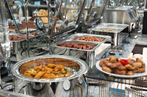 a buffet line with several trays of food at SQ Hang Gai Hotel & Spa in Hanoi