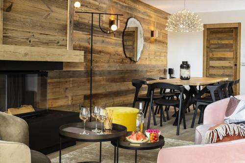- un salon avec une cheminée et une table avec des verres à vin dans l'établissement Résidence Caseblanche - Chalet MCFOGGIN MAE-9011, à Saint-Martin-de-Belleville