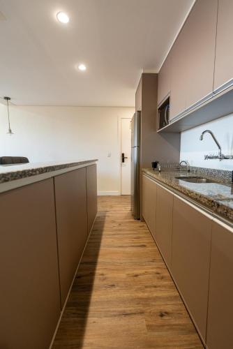 a large kitchen with wooden flooring and stainless steel appliances at Metropolitan Flats in Curitiba
