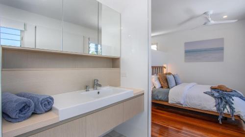 Un baño con lavabo y cama. en Verano, en Casuarina