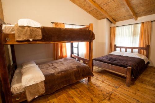two bunk beds in a room with wooden floors at Hotel Santa M la Cocha in Pasto