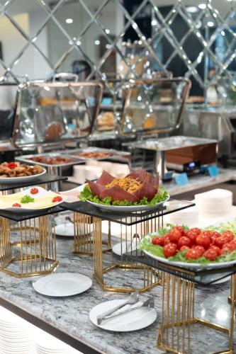 a buffet with several plates of food on a table at SQ Hang Gai Hotel & Spa in Hanoi