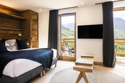 - une chambre avec un lit, une télévision et un balcon dans l'établissement Résidence Caseblanche - Chalet MCFOGGIN MAE-9011, à Saint-Martin-de-Belleville