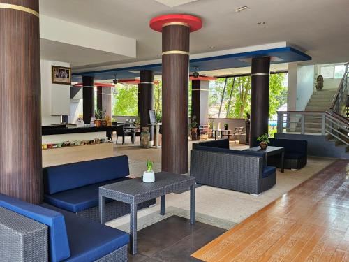 a lobby with blue couches and tables and a staircase at AM Surin Place - SHA Extra Plus in Surin Beach