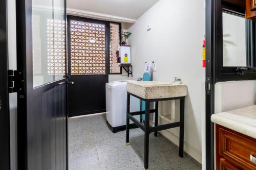 a bathroom with a sink and a washing machine at Lofts By Verticca in Santa Cruz Tecamac