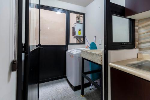 a small bathroom with a sink and a door at Lofts By Verticca in Santa Cruz Tecamac