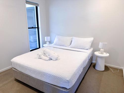 a bedroom with a bed with a stuffed animal on it at Theme Park Retreat Coomera 5 Beds Villa in Gold Coast