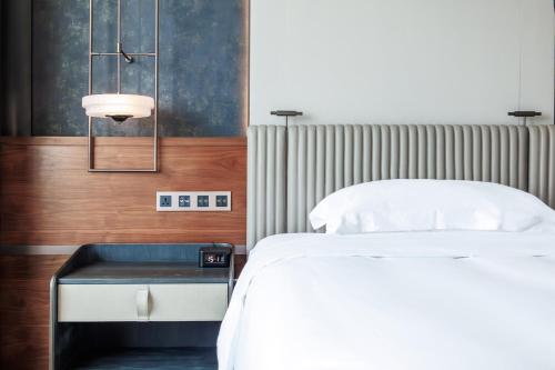 a bedroom with a bed and a side table at InterContinental Haikou Seaview by IHG in Haikou