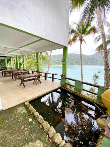 a patio with a koi pond in front of the ocean at Pousada Ponta da Ilha, Ilha Grande, Angra dos Reis in Angra dos Reis