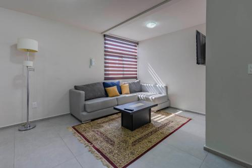 a living room with a couch and a table at Lofts By Verticca in Santa Cruz Tecamac