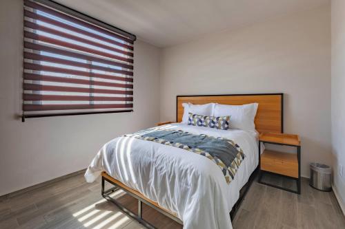 a bedroom with a large bed and a window at Lofts By Verticca in Santa Cruz Tecamac
