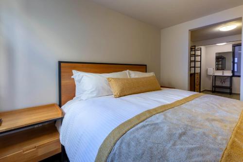 a bedroom with a large bed with a wooden headboard at Lofts By Verticca in Santa Cruz Tecamac