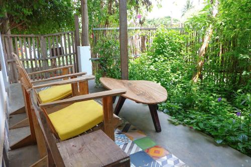 a wooden chair and a bench on a patio at Stop And Go Làng Chài Bàu Trắng in Ấp Thiẹn Ái