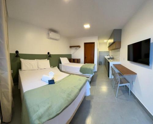 a hotel room with two beds and a television at Mar de Maragogi Flats in Maragogi