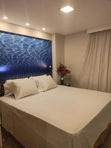 a bedroom with a bed with a large painting on the wall at Flat Beira Mar Meireles in Fortaleza