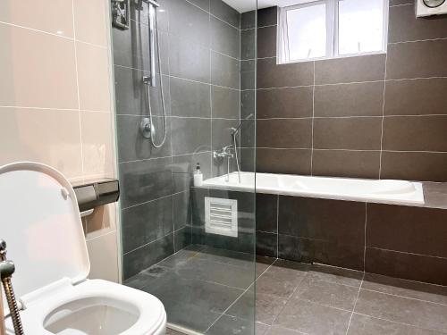a bathroom with a shower and a toilet and a tub at HillMark Suites in Ayer Keroh