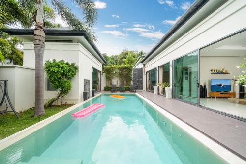 a swimming pool in the backyard of a house at Relax & Enjoy Stay! Elegant 3BR Pool Villa Talosy in Rawai Beach