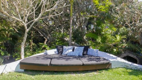 a bed in the grass in front of some trees at Shambhala @ Byron in Byron Bay