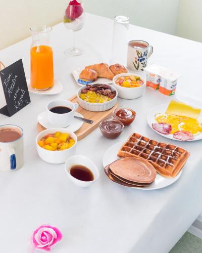 a table with breakfast foods and drinks on it at Evasion en plein cœur de la ville T2 Jacuzzis Sauna et piscine au centre de Port-Louis in Port-Louis