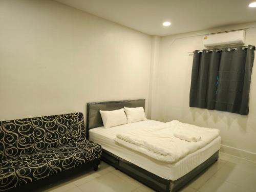 a small bedroom with a bed and a chair at เอส บี โฮเทล SB Hotel in Betong
