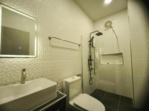 a bathroom with a sink and a toilet and a shower at เอส บี โฮเทล SB Hotel in Betong