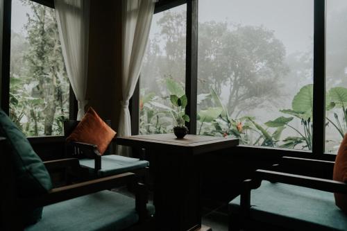 a room with a table and a large window at Amour Resort Bavi in Hanoi