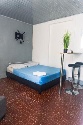 a bedroom with a bed and a table and two stools at Coliving La Rebeca Pereira in Pereira