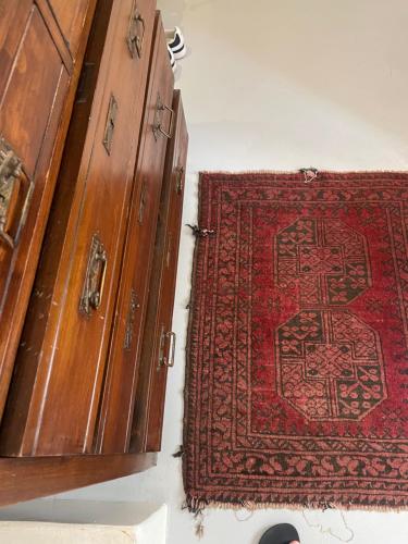 a red rug sitting next to two wooden cabinets at Villetta Erato-picturesque studio in Halki
