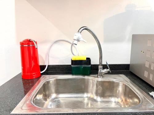 a kitchen counter with a sink and a red appliance at HillLand Suites in Ayer Keroh