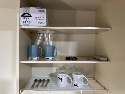 a cupboard with cups and mugs in it at Rest collection Fushimi-Inari Kyoto in Kyoto