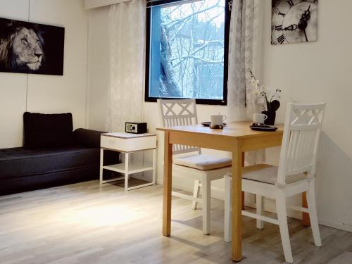 a living room with a table and chairs and a couch at Puisto mökki in Rauma