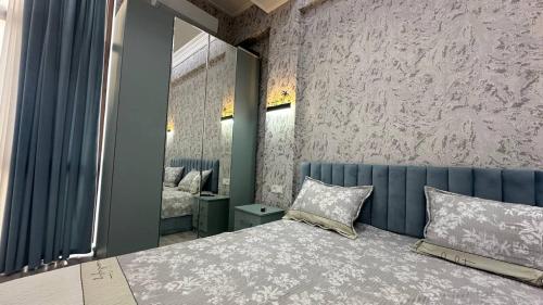 een slaapkamer met een groot bed en een spiegel bij Parkent luxe 261 in Tasjkent