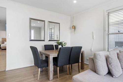 a dining room with a table and chairs and a couch at Villa with Seaside Soul Newly Renovated in Caves Beach