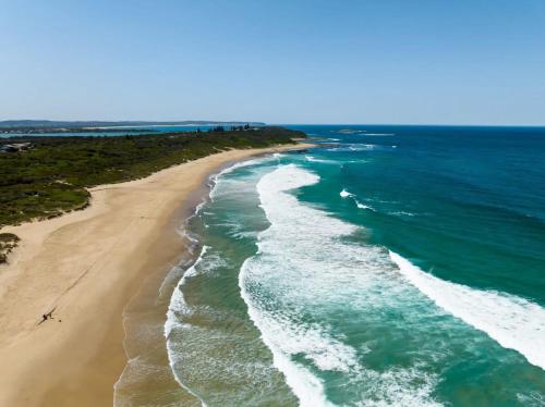 an aerial view of the ocean and a beach at Villa with Seaside Soul Newly Renovated in Caves Beach