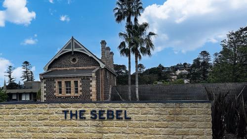 a building with a sign on a brick wall at Apartment 215 Sebel Kiama in Kiama