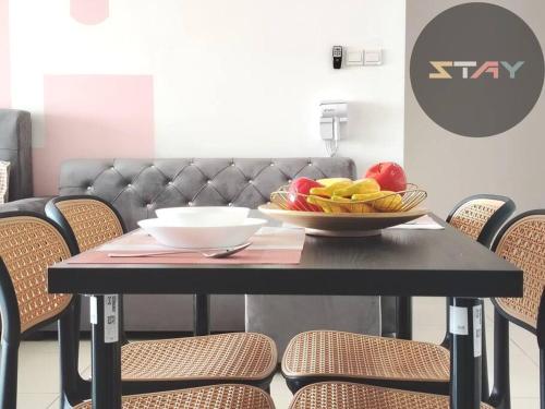 une table noire avec un bol de fruits dessus dans l'établissement S21-13A Teega Family Cozy Suites Netflix BySTAY, à Iskandar Puteri