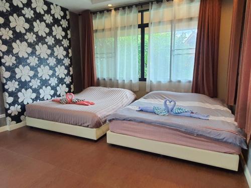 two beds sitting next to each other in a bedroom at Preme House Boutique in San Sai