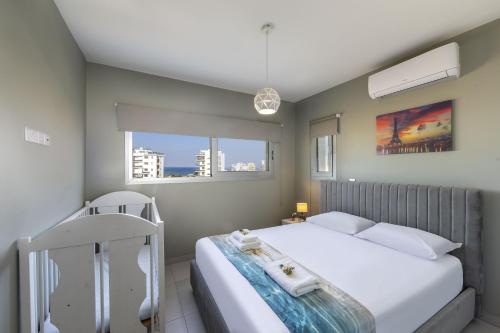 a bedroom with a white bed and two windows at Majestic Sunset Salt Lake Views 300m From Beach in Larnaka