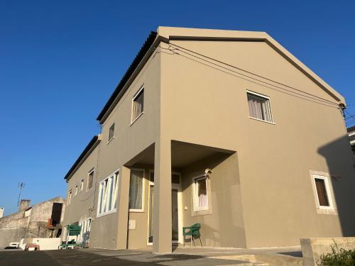 a large white building with a lot of windows at Lugar de Passos in Sesimbra
