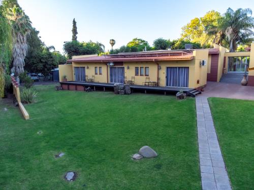 a house with a lawn in front of it at Sunriver Kalahari Lodge Riverside stay in Upington in Upington
