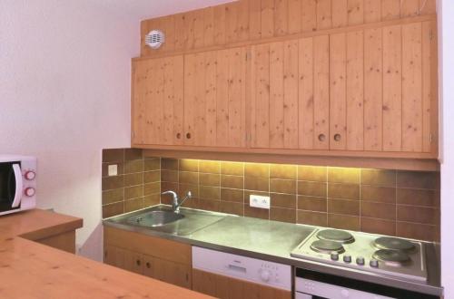 une cuisine avec un évier et une cuisinière dans l'établissement Résidence Les Dauphinelles - 2 pièces cabine pour 4/6 personnes situé à Méribel Altiport proche des pistes de ski et du golf MAE-2035, à Les Allues
