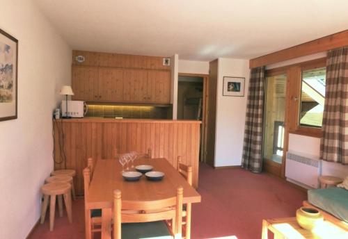 une cuisine et une salle à manger avec une table et des chaises dans l'établissement Résidence Les Dauphinelles - 2 pièces cabine pour 4/6 personnes situé à Méribel Altiport proche des pistes de ski et du golf MAE-2035, à Les Allues