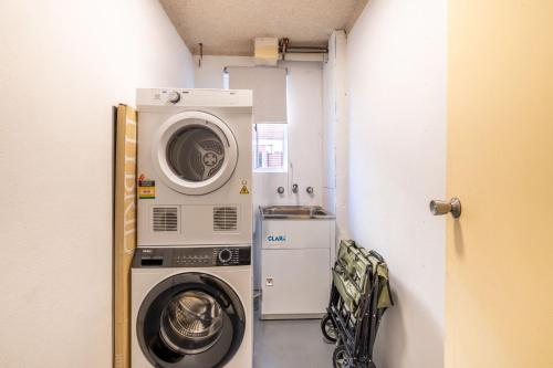 a small laundry room with a washer and dryer at Yarramundi, 7-47 Magnus St - spectacular views in the heart of Nelson Bay in Nelson Bay